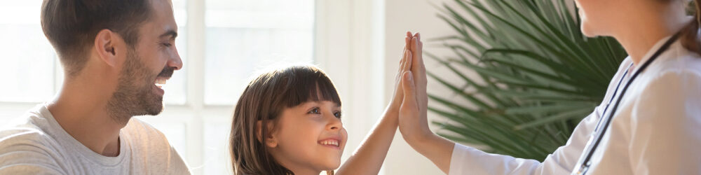 Father with daughter giving doctor a high-five