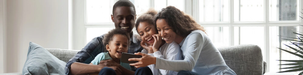 happy family looking at cell phone