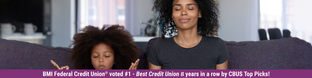 mother and daughter meditating on couch