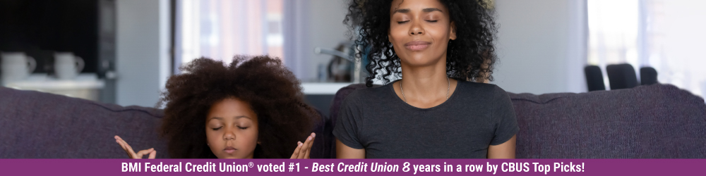 mother and daughter meditating on couch