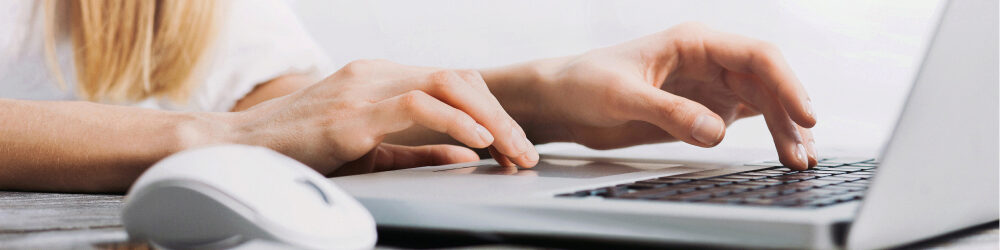 female hands typing on laptop