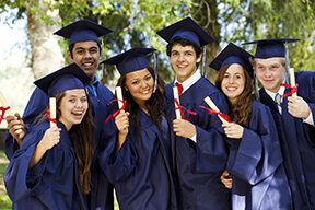 graduates holding up their diplomas
