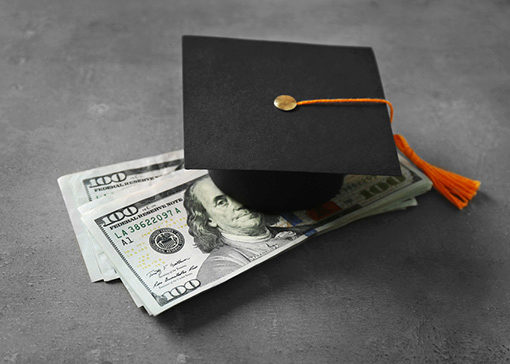cap and diploma with bills