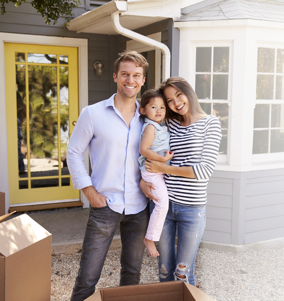 family in front of house smiling