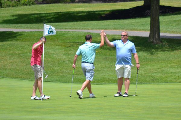 golfers high-fiving and smiling