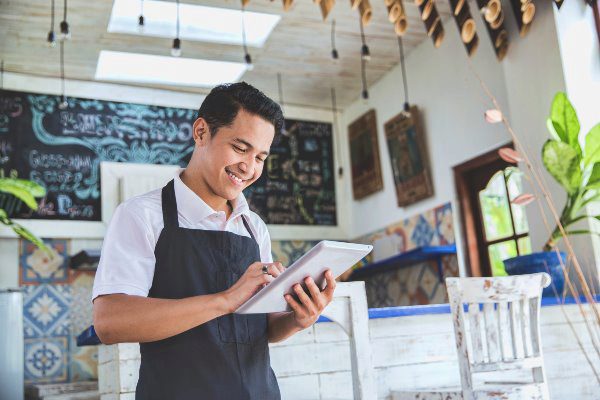 guy in shop with ipad smiling