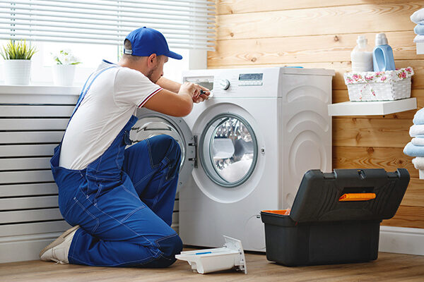 man repairing a washer and dryer