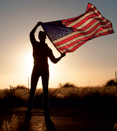 military guy with flag at sunset