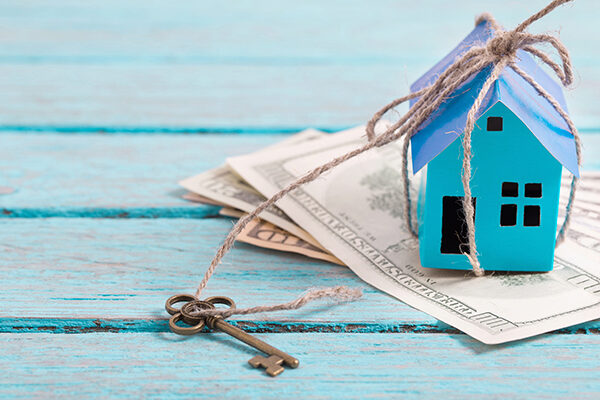 model home with keys on top of money