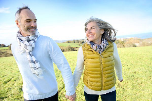 older couple walking through a field