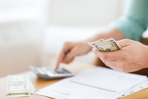 person counting money and using a calculator