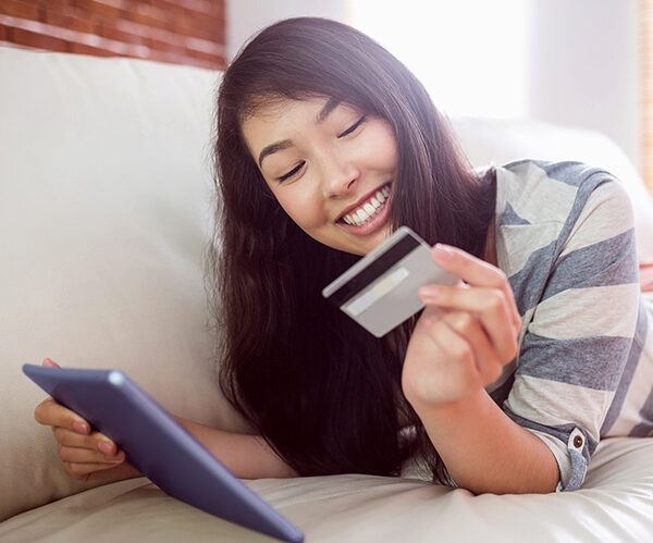 Girl looking at her credit card and smiling 
