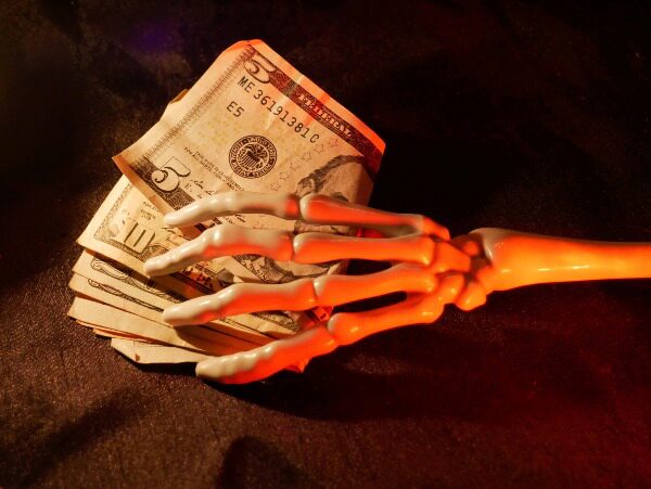 skeleton hand on money