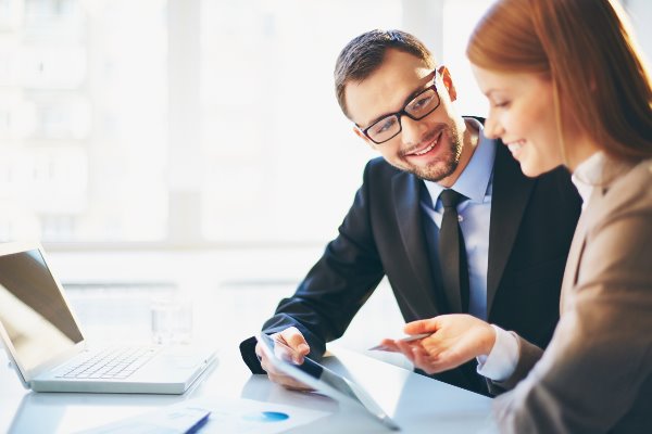 two business people looking over a contract smiling